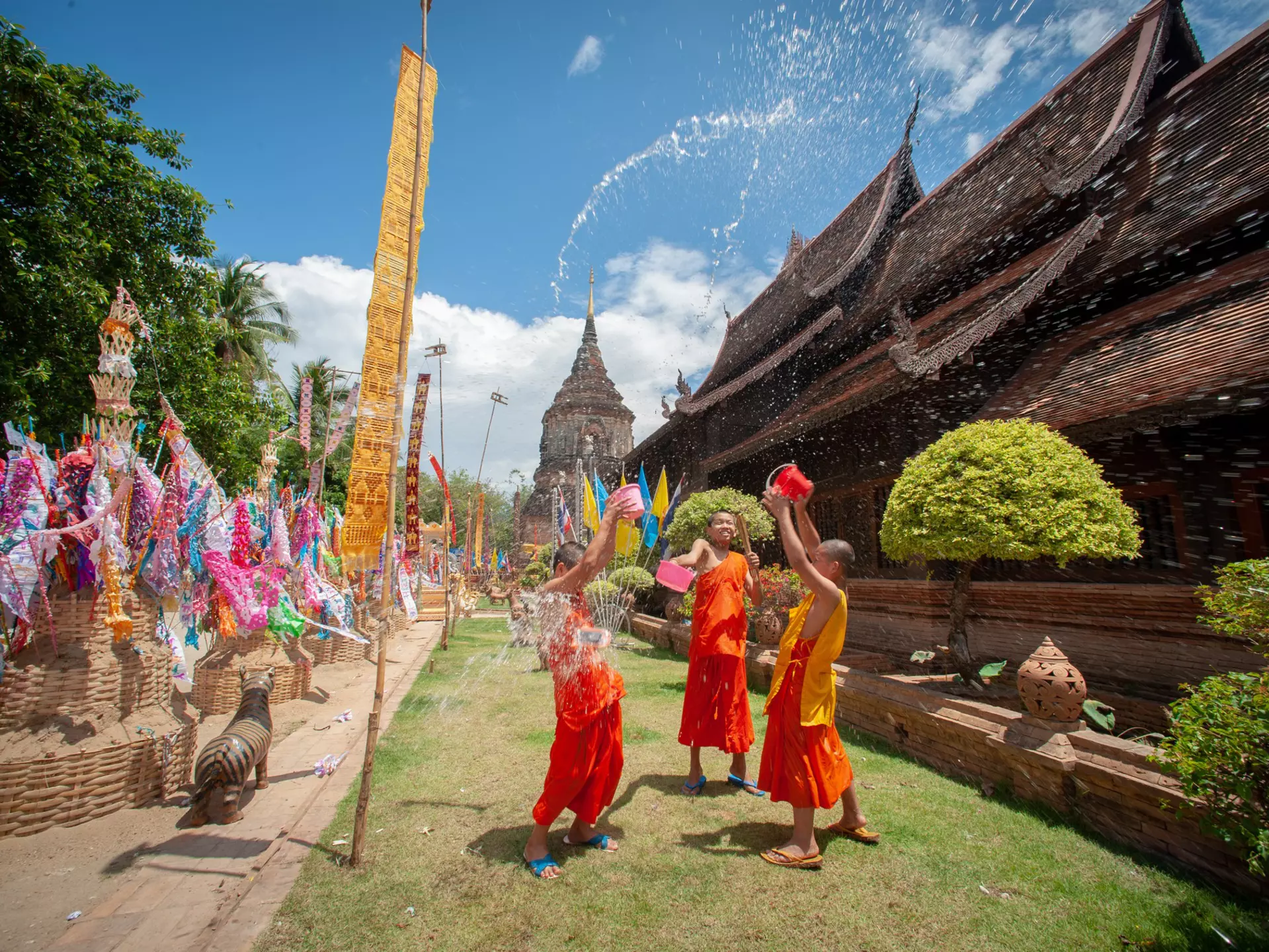 Monks splashing water Songkran Festival is celebrated in a traditional New Year's Day, A family comes to decorat tung in the temple Wat Phra singh in Chiang Mai,Thailand.  