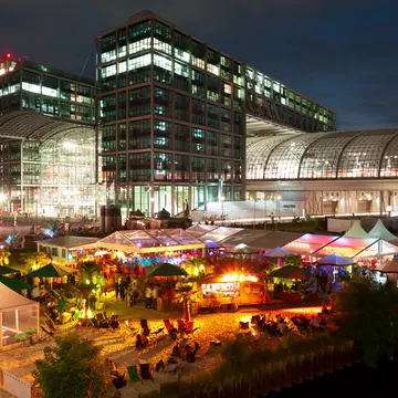 An outside bar in Berlin is busy at nighttime.