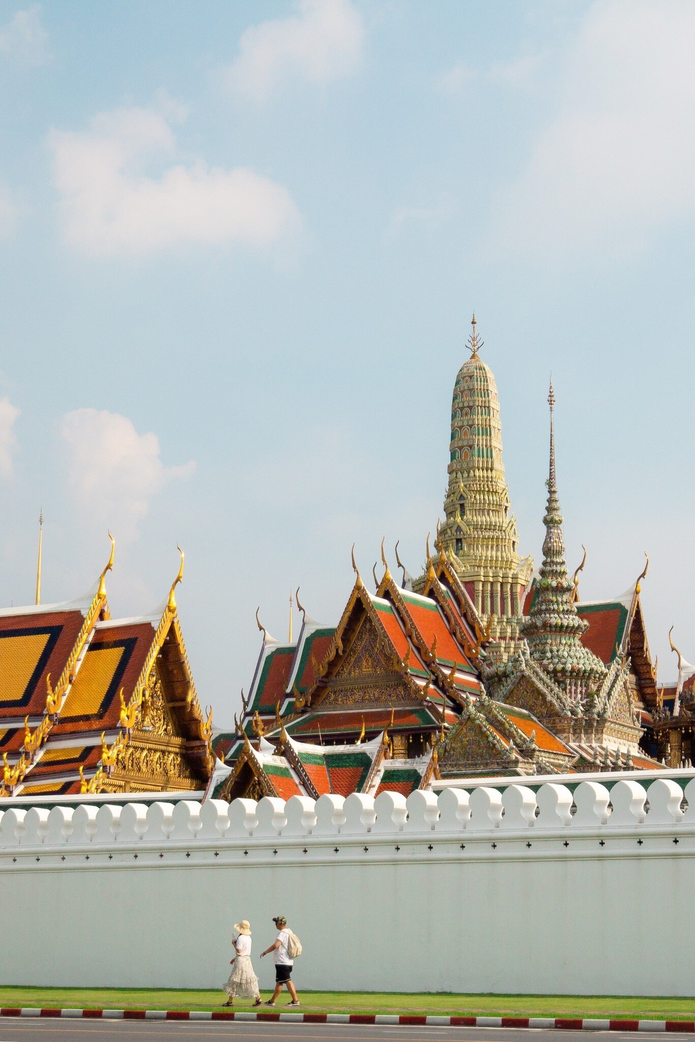A tourist couple walking at Wat Phra Kaew in Bangkok, Thailand.