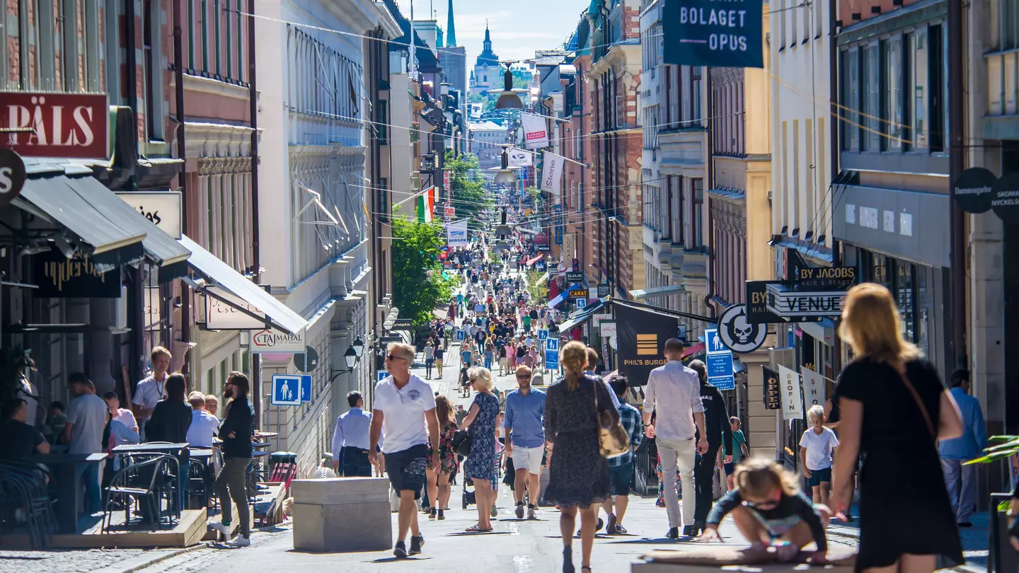 View of crowds of pedestrians on a central shopping street on a sunny day in Stockholm, Sweden.