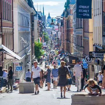 View of crowds of pedestrians on a central shopping street on a sunny day in Stockholm, Sweden.