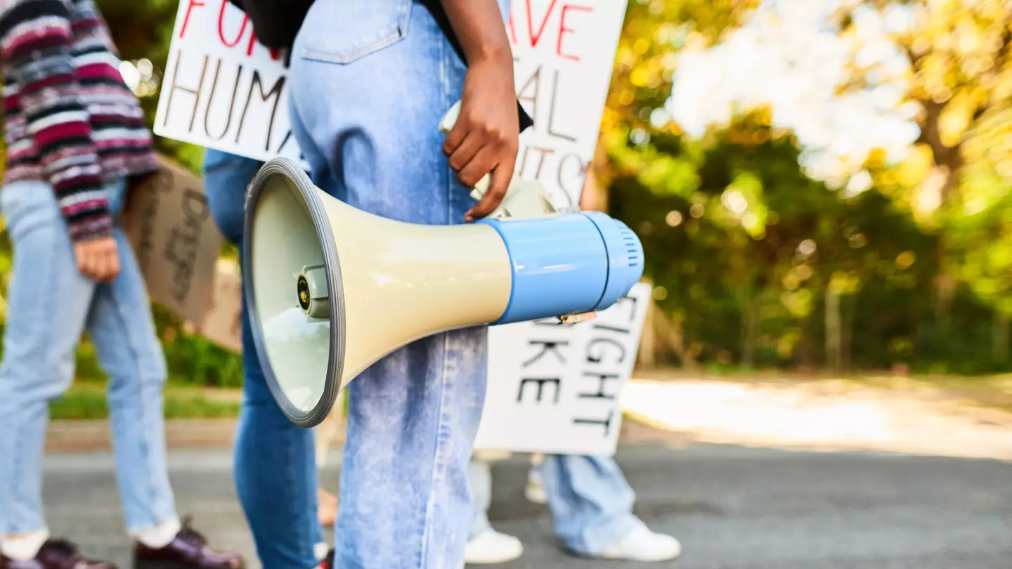 Woman standing with a megaphone during a women's rights day march