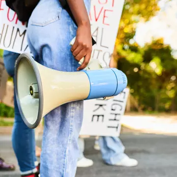 Woman standing with a megaphone during a women's rights day march