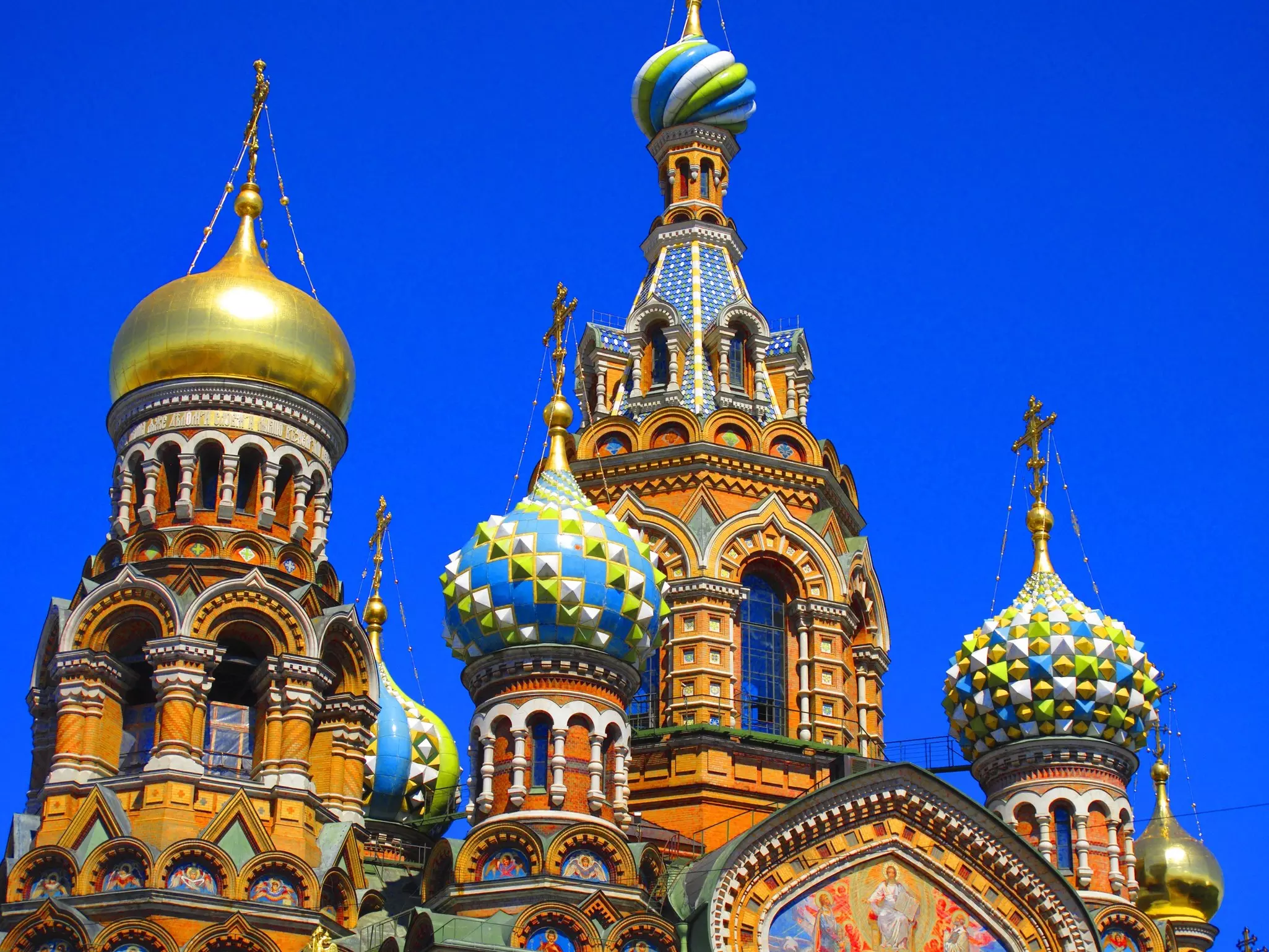 The domes of a colorful Russian Orthodox church against a blue sky