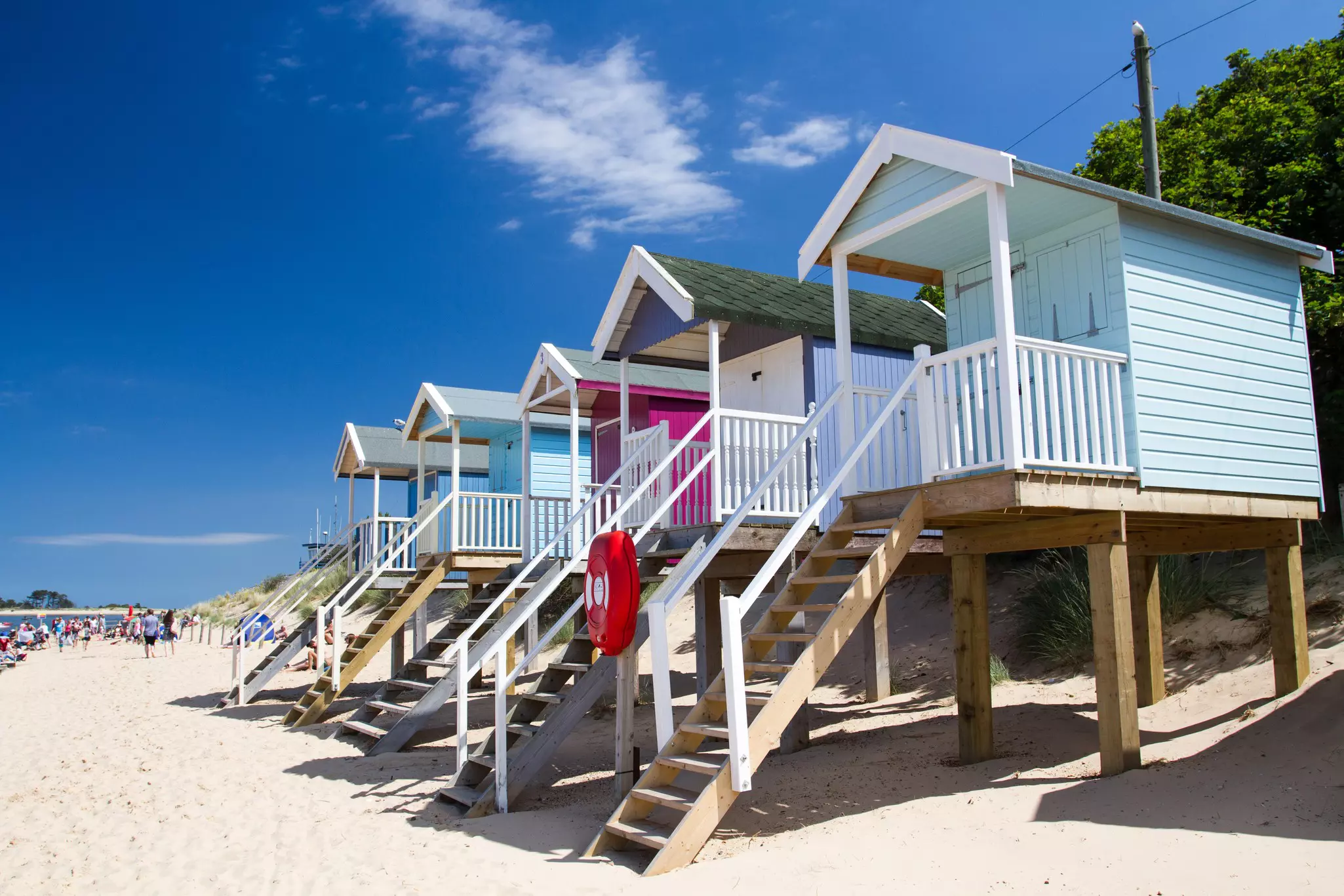 Rows of colorful, wooden beach huts on the sandy beach of Wells-next-the-Sea, Norfolk, UK.