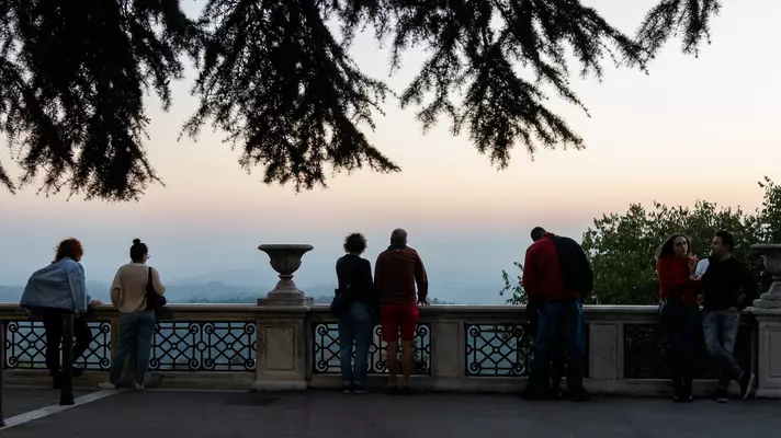 People watch the sunset over Umbria from a square in Perugia