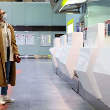 Woman With Luggage Waiting At Airport Check-In Counter  Dmitry Marchenko GettyImages-1235141874 rfc.jpg