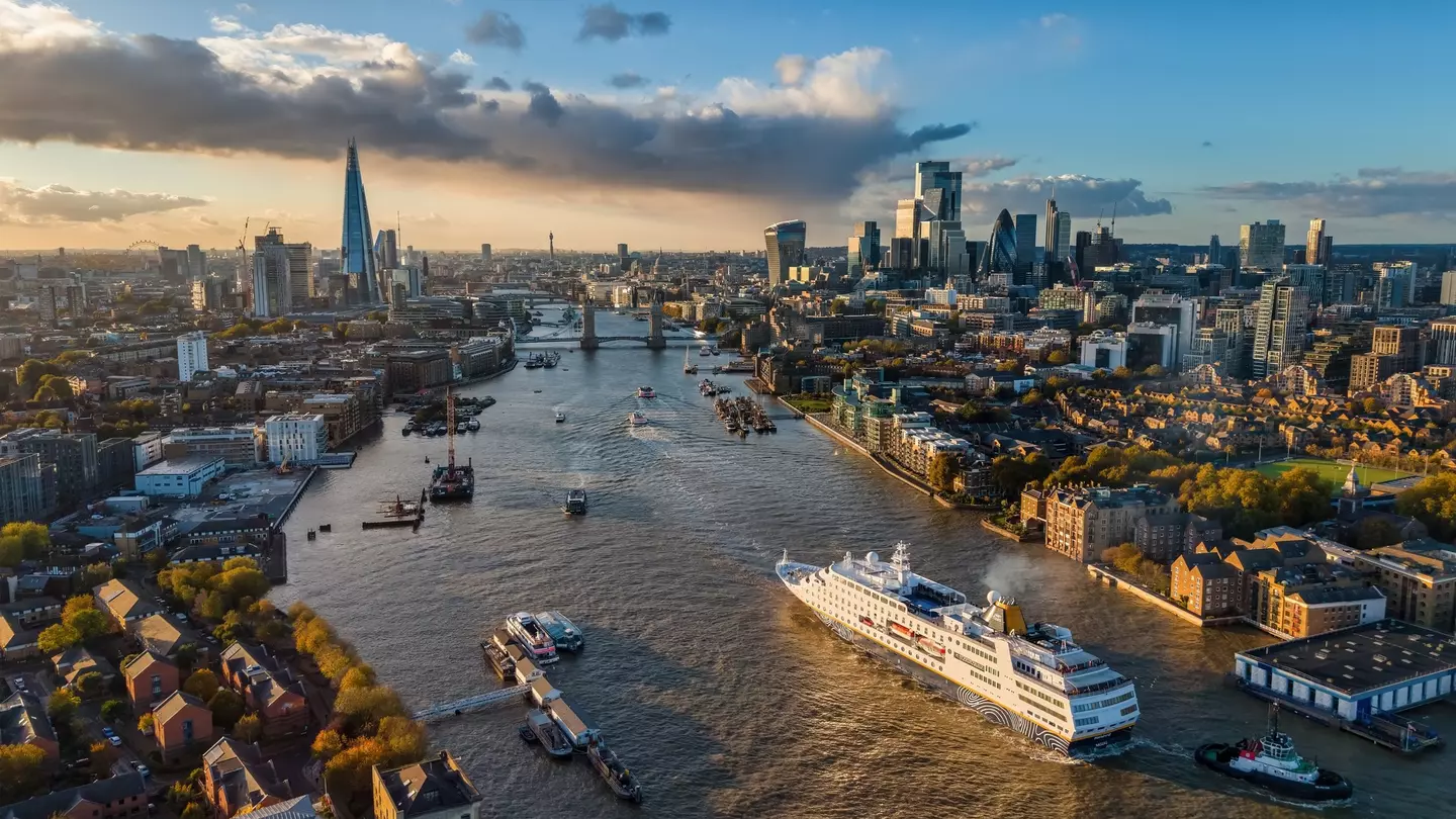 London, England - October 25th 2025: aerial view of the cruise ship MS Hamburg traveling over the Thames river towards Tower Bridge