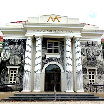 Columned museum entrance covered in black-and-white murals, its name above the door, San Juan, Puerto Rico