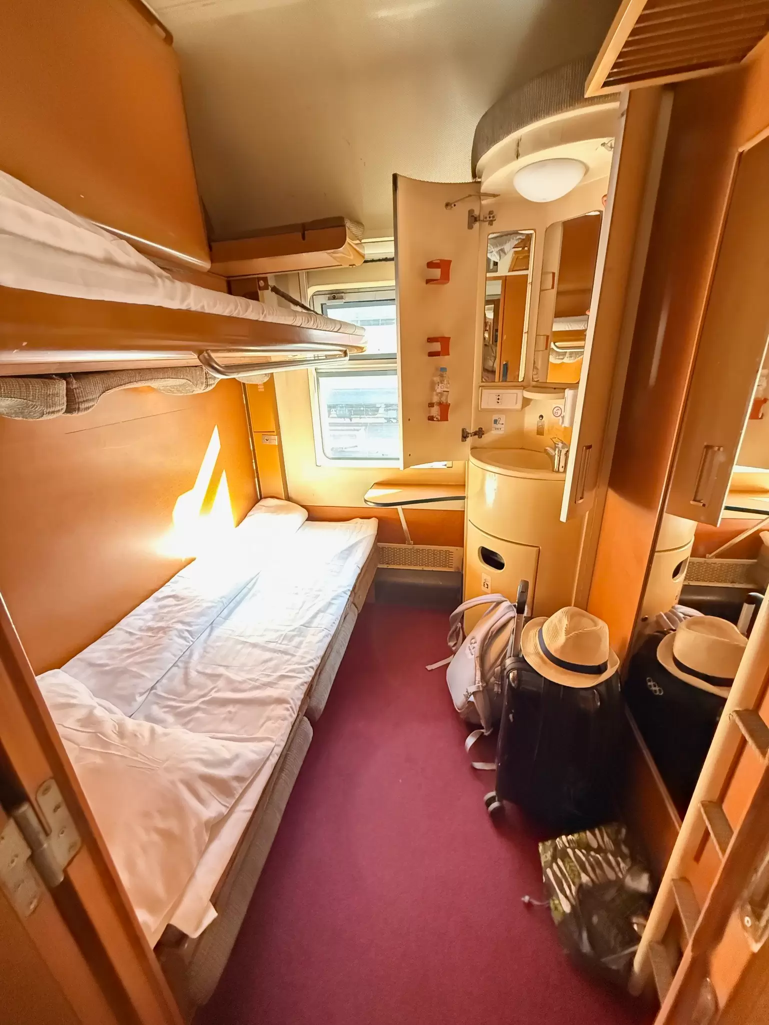 A narrow bed in a private train compartment.