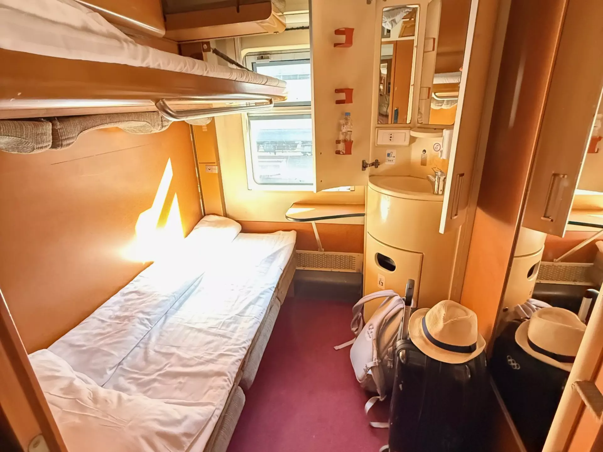 A narrow bed in a private train compartment.