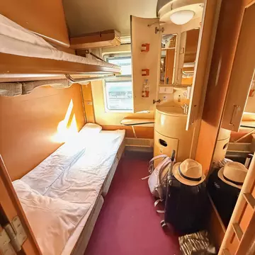 A narrow bed in a private train compartment.