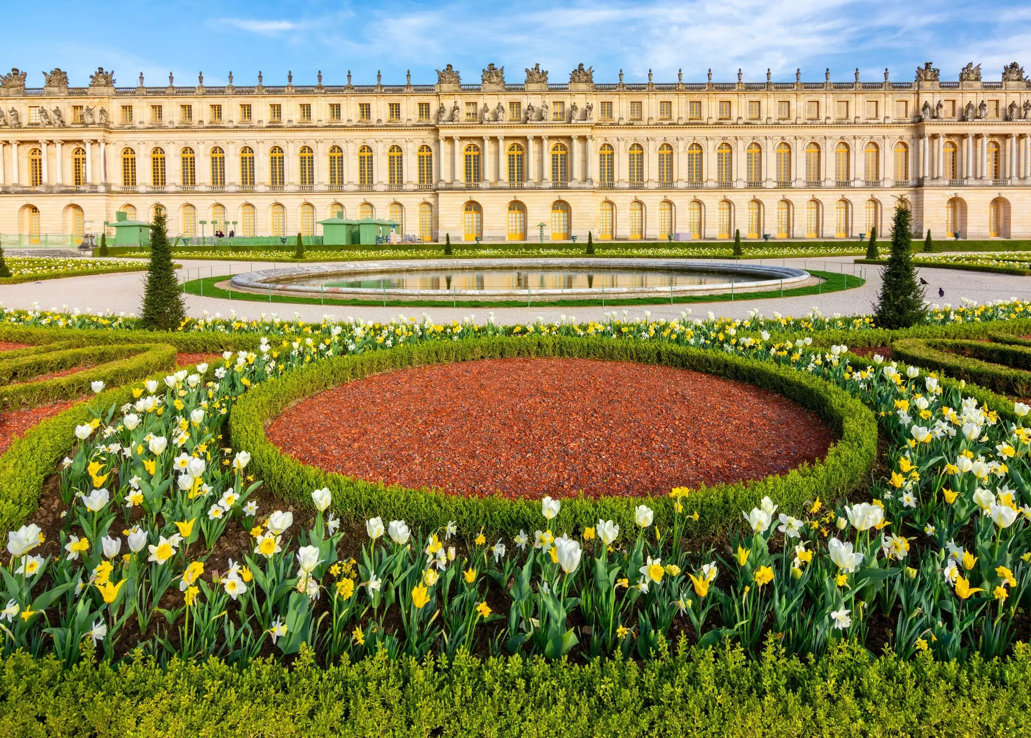 Spring flowers in bloom in a garden in front of an opulent palace.
