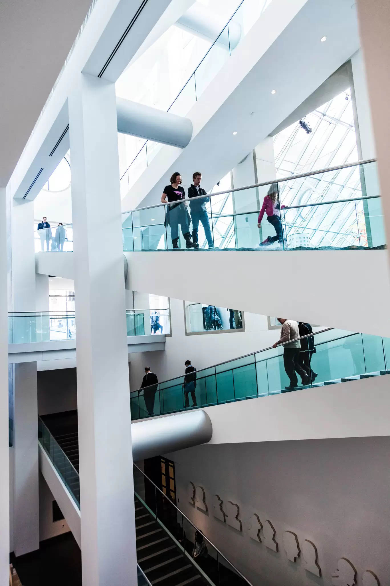 People walking on two separate sets of stairs that are bathed in natural light