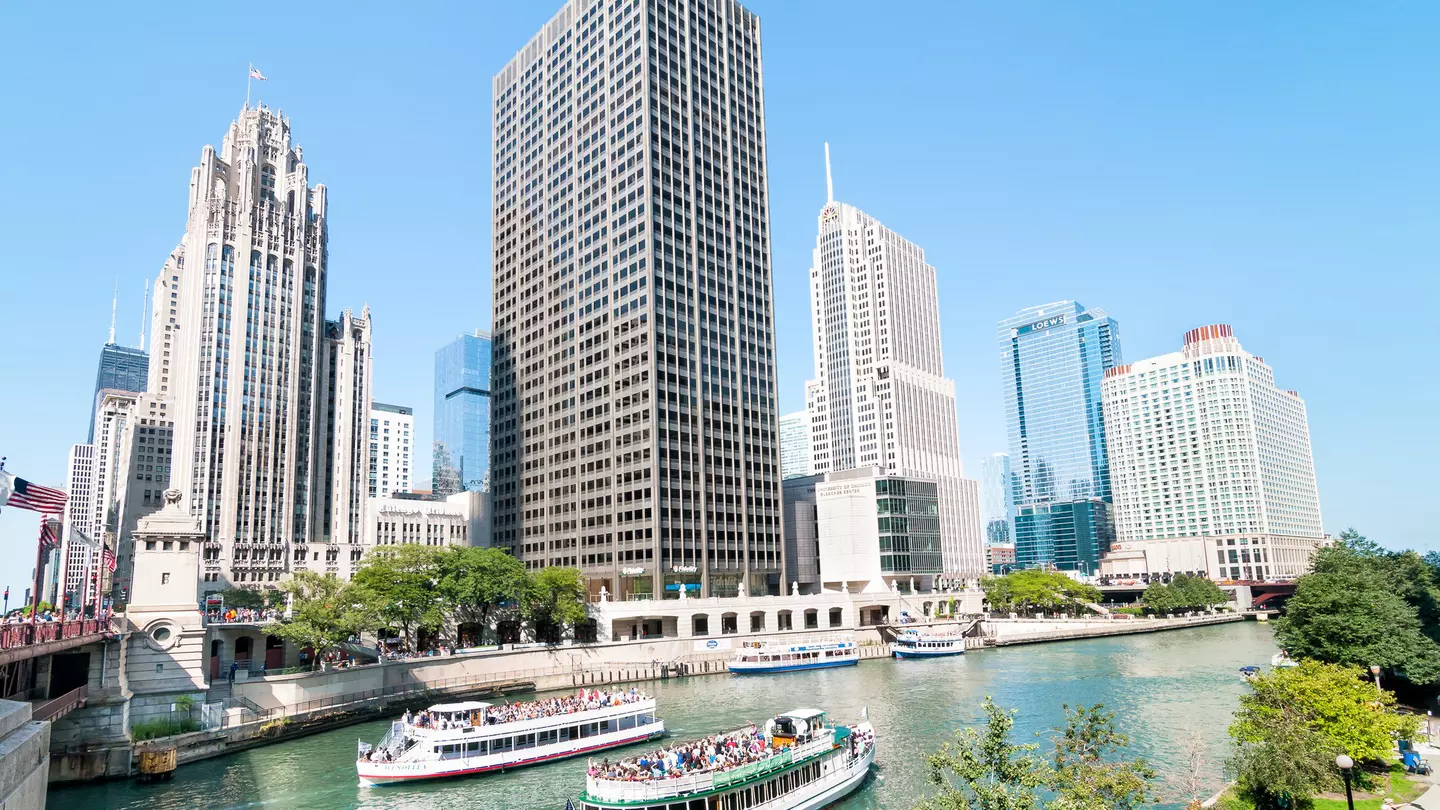 Ferries travelling on a river towards Lake Michigan with the Chicago skyline