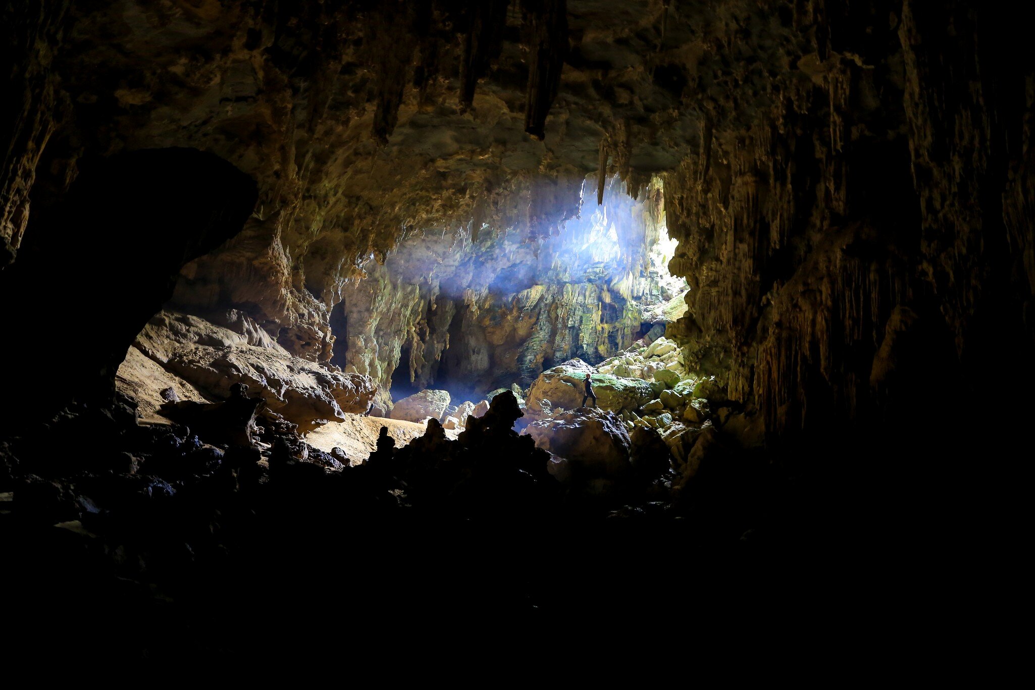 A caver stands near the entrance of Tu Lan Caves.