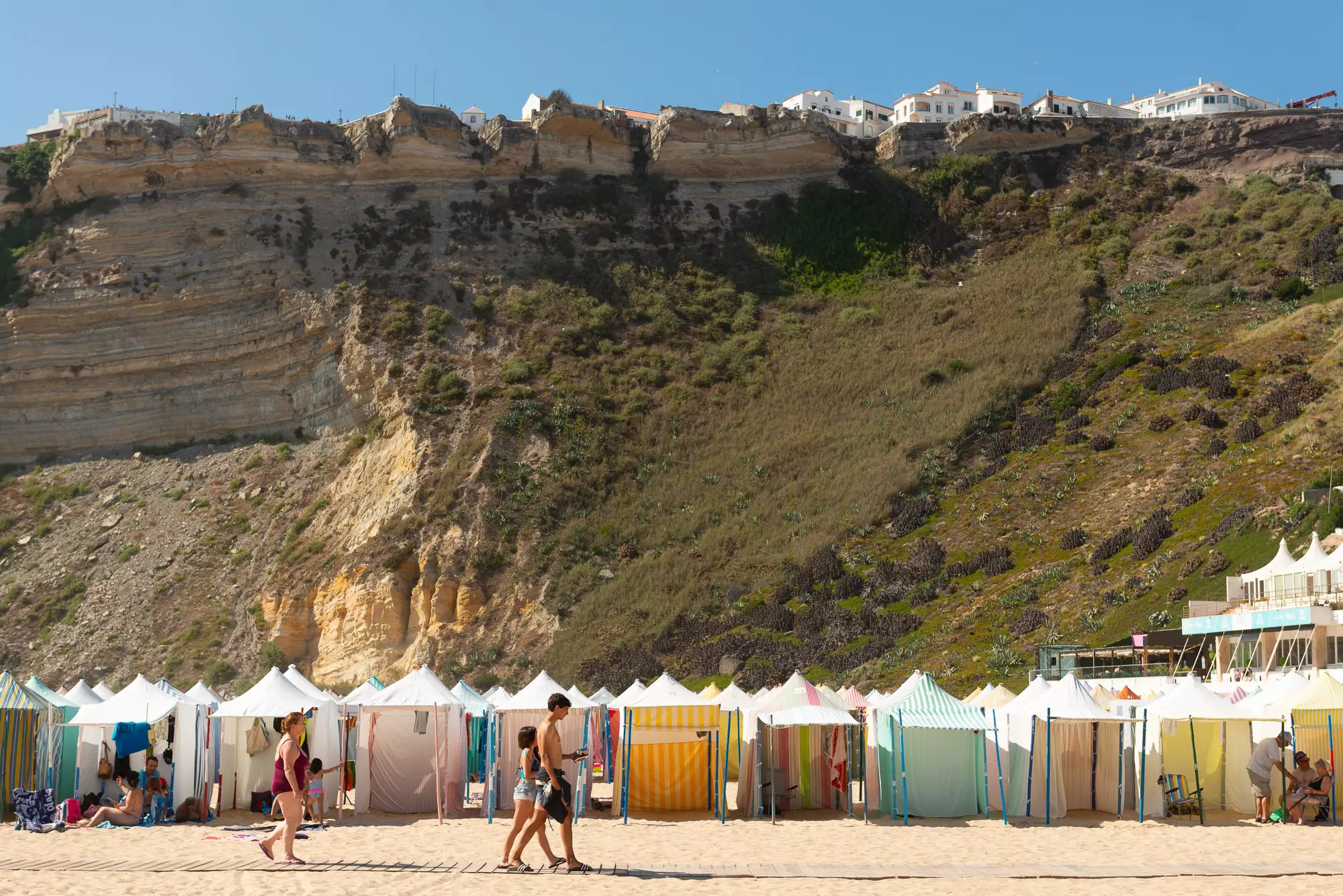 Traditional ​​​​​​cabanas known as barracas pack the beach at Nazaré © Austin Bush / Lonely Planet