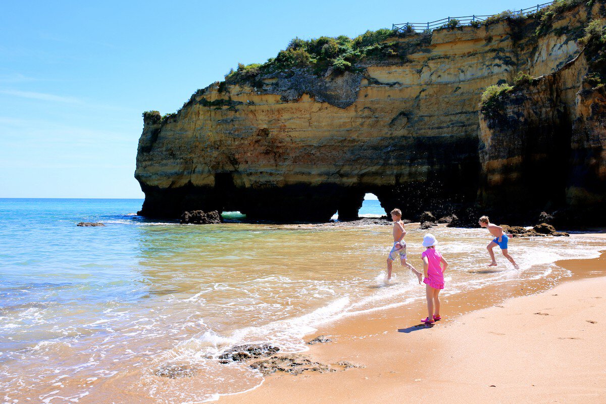 Wonderful view of Praia dos Estudantes in south of Portugal. Happy children playing, splashing and swimming in the ocean at one of the most beautiful beaches in Lagos, Algarve region; Shutterstock ID 618802001; your: Brian Healy; gl: 65050; netsuite: Lonely Planet Online Editorial; full: Free things in the Algarve