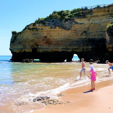 Wonderful view of Praia dos Estudantes in south of Portugal. Happy children playing, splashing and swimming in the ocean at one of the most beautiful beaches in Lagos, Algarve region; Shutterstock ID 618802001; your: Brian Healy; gl: 65050; netsuite: Lonely Planet Online Editorial; full: Free things in the Algarve
