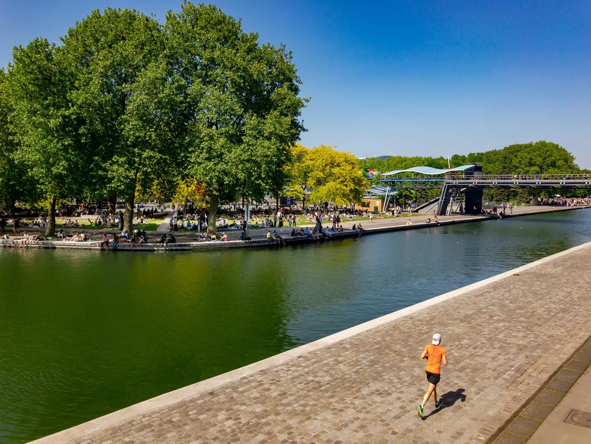 A man running through La Villette park with a crowd of people gathered on the grass over the other side of Canal de l'Ourcq.
1109568341
beautiful, city, city life, france, good times, green, holidays, la villette, lake, landscape, man, nature, orange, outdoor, paris, park, picnic, race, river, run, runner, scene, sky, sport, square, summer, sun, sunny, tourism, travel, tree, trees, urban, urban scene, view, water
