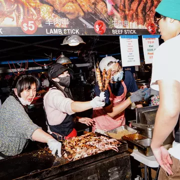a vendor selling skewers at the market. 