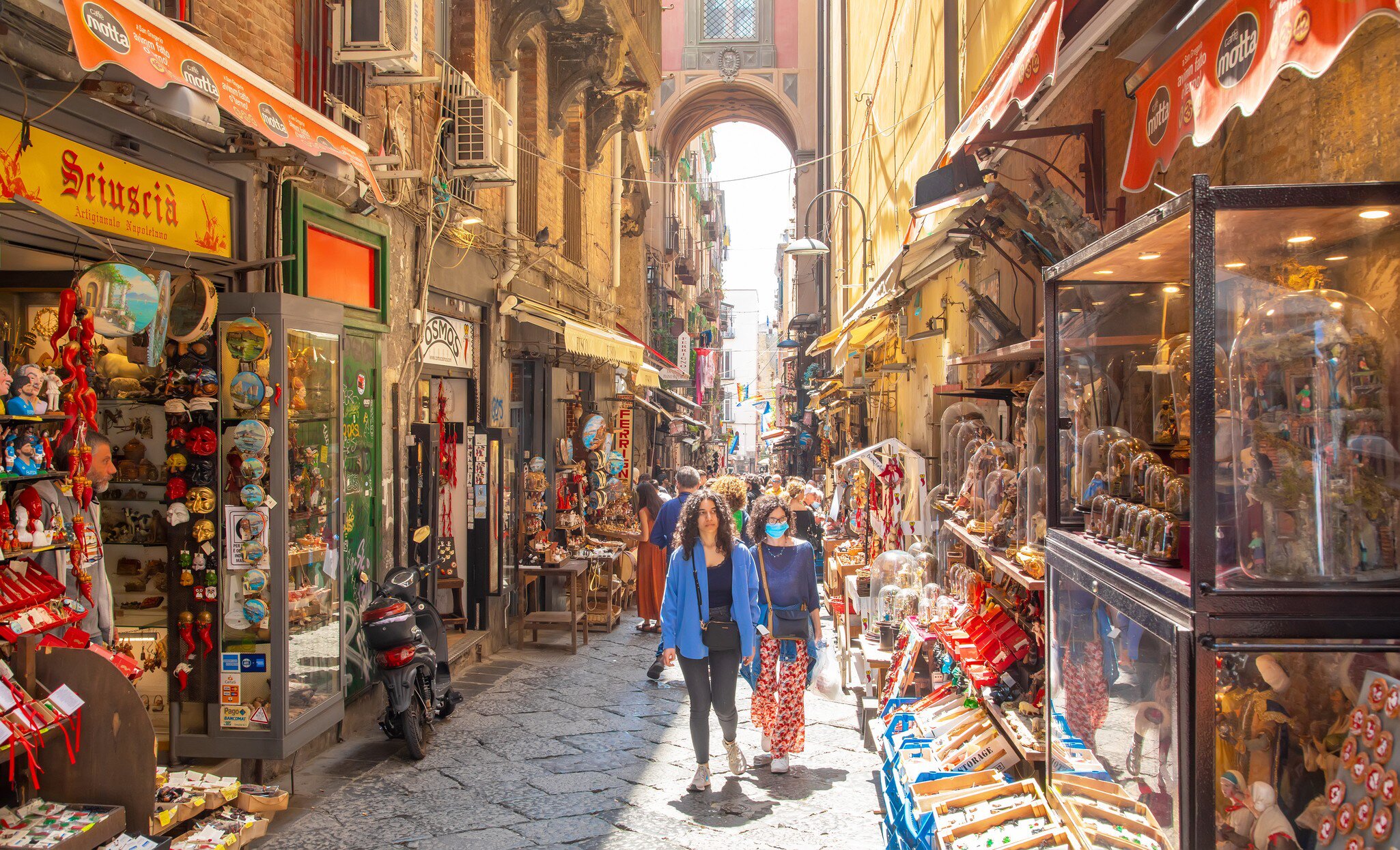 Naples, Italy - 10 June, 2022: Via San Gregorio Armeno street and Neapolitan souvenirs market, historic center of the city, people walking on a street.