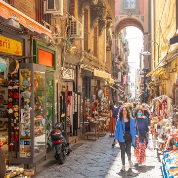 Naples, Italy - 10 June, 2022: Via San Gregorio Armeno street and Neapolitan souvenirs market, historic center of the city, people walking on a street.