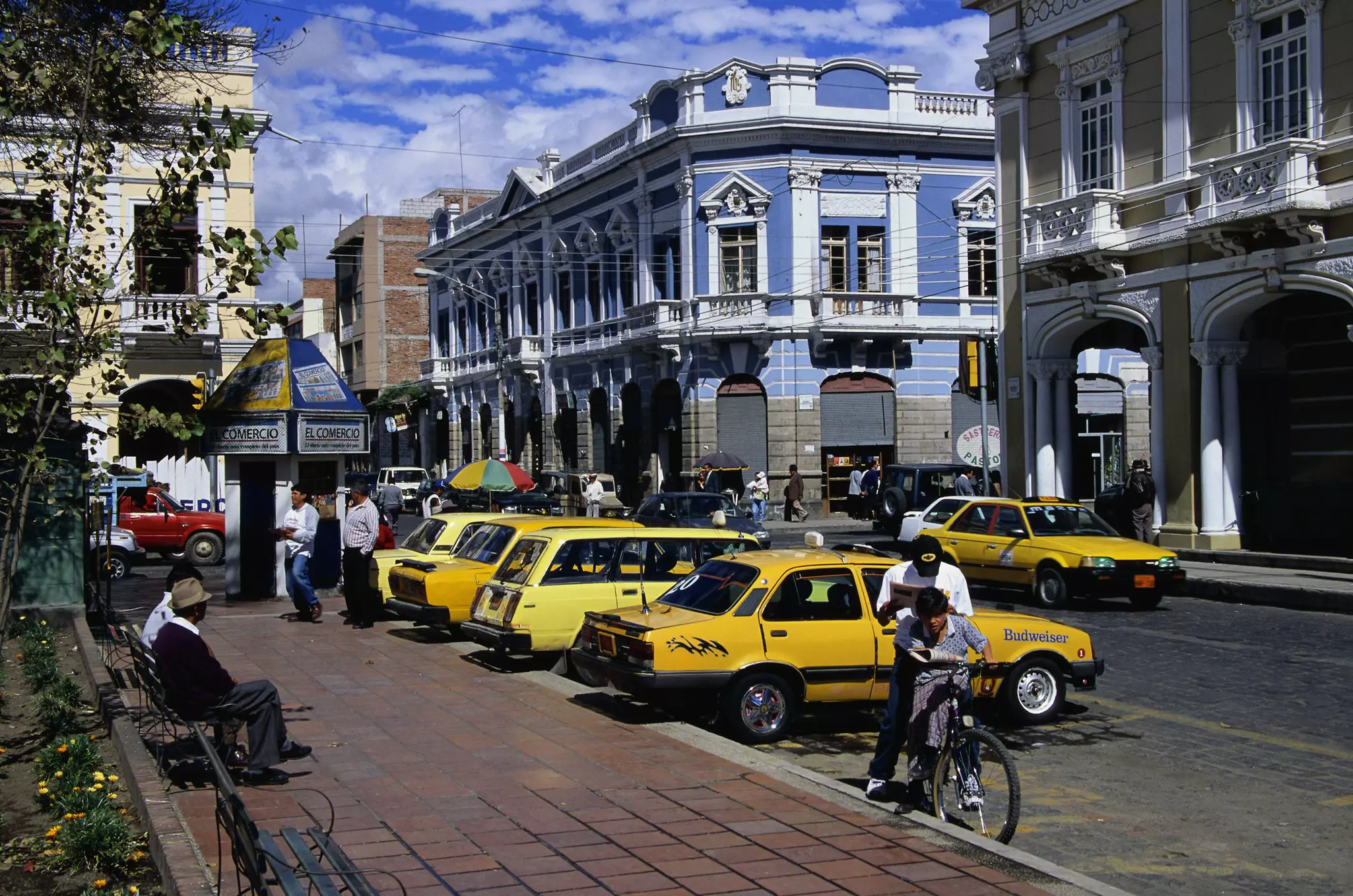Yellow taxis parked in a line next to the sidewalk in Riobamba, Ecuador