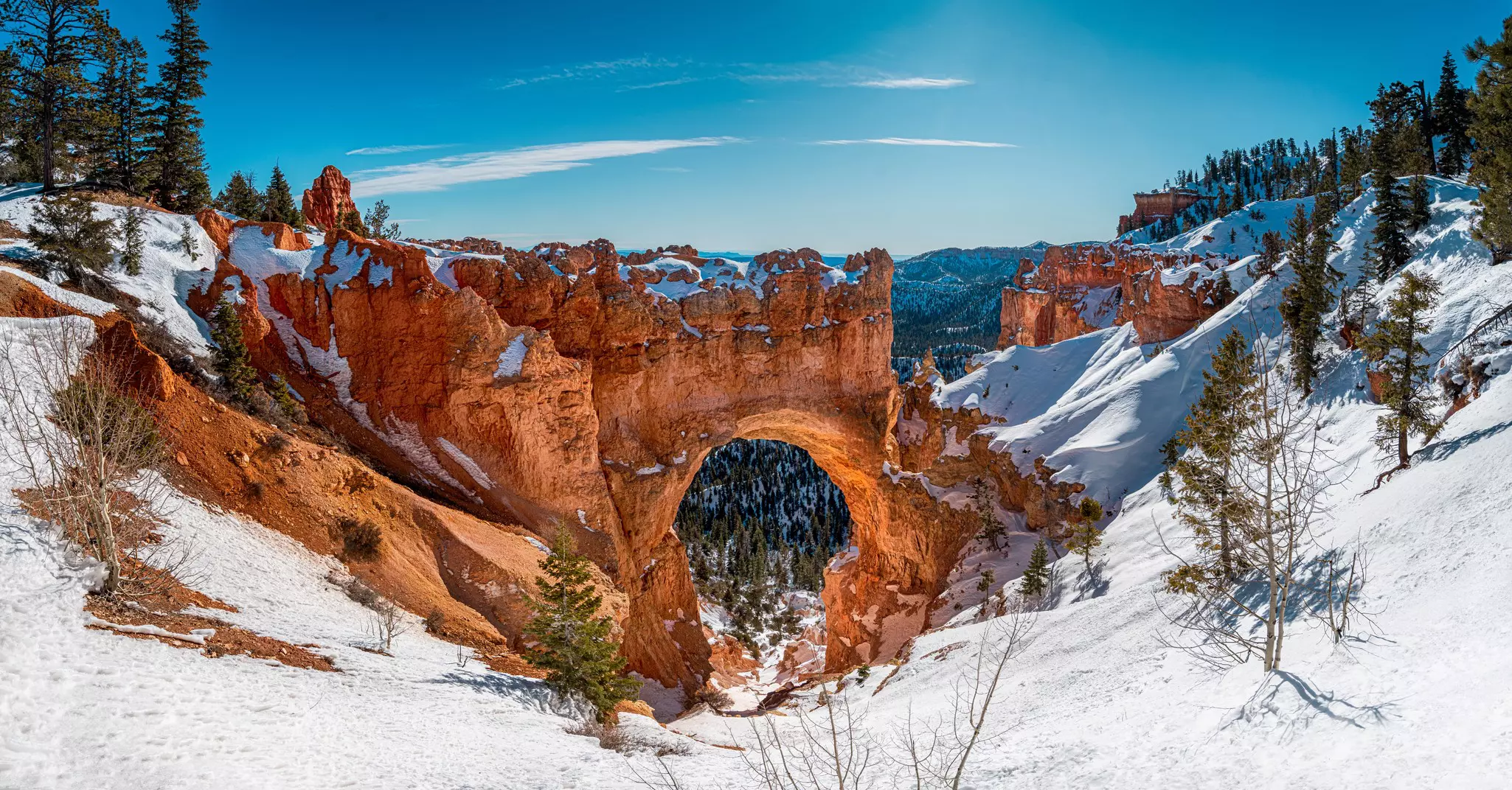 A rock arch topped with snow