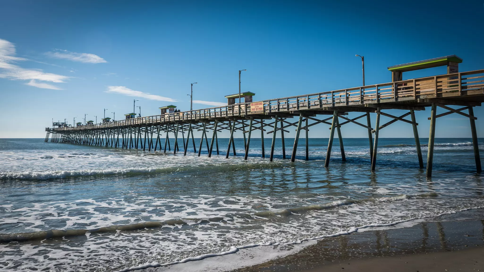 Bogue Inlet pier with blue skies and waves