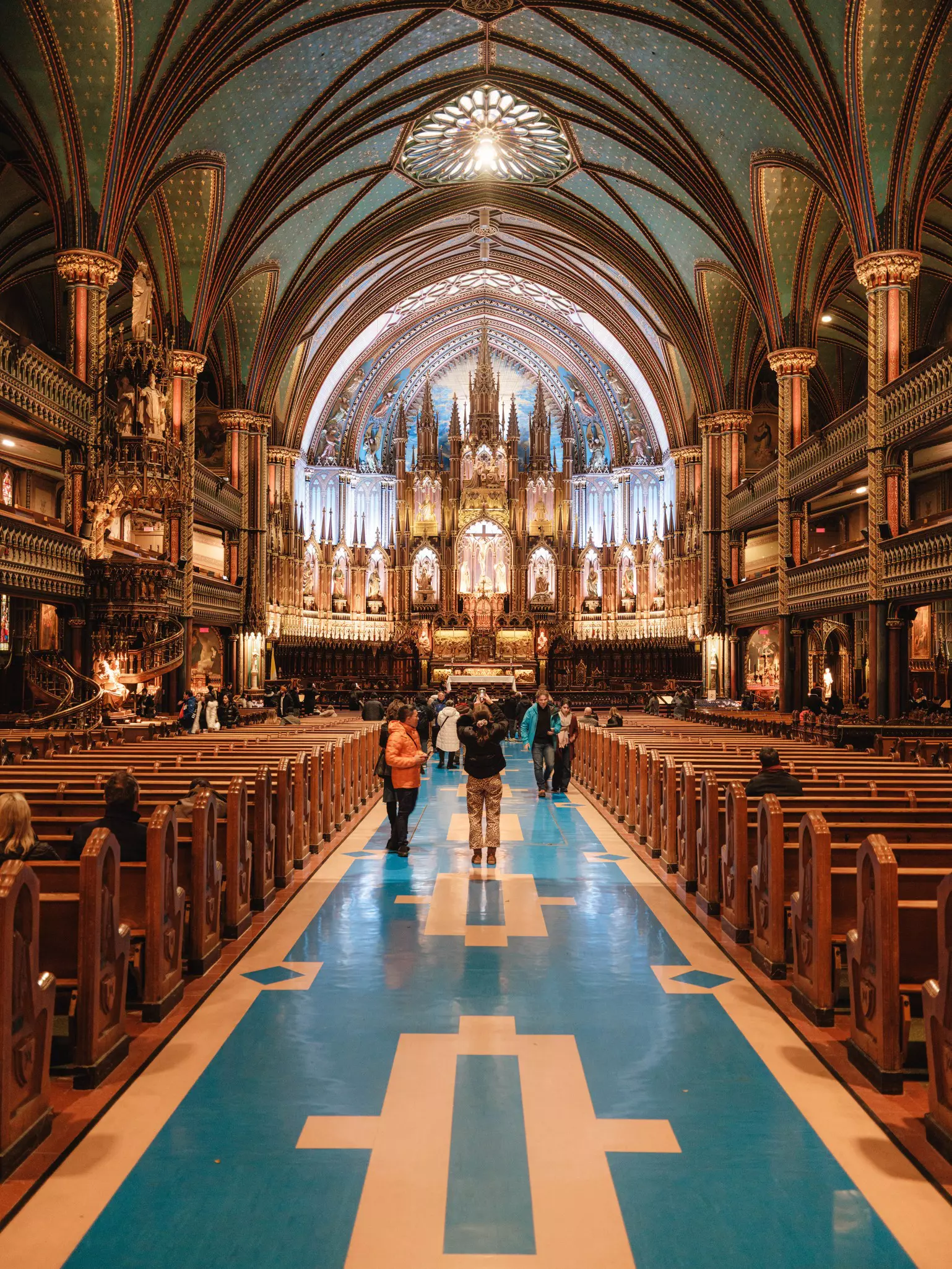 View of a church with stained glass and people taking photographs in it