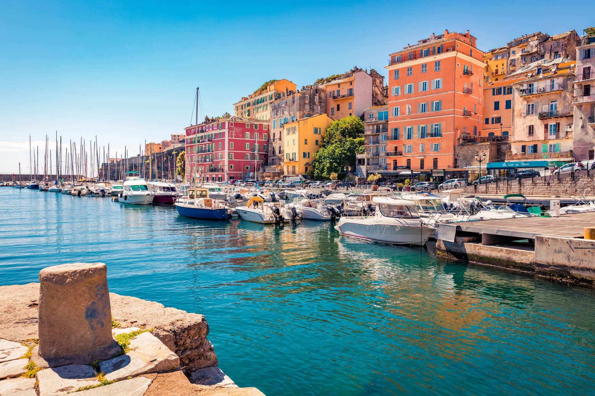Colorful houses on the shore of Bastia port. Bright morning view of Corsica island, France, Europe. Magnificent Mediterranean seascape with yacht. 
