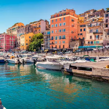 Colorful houses on the shore of Bastia port. Bright morning view of Corsica island, France, Europe. Magnificent Mediterranean seascape with yacht. 