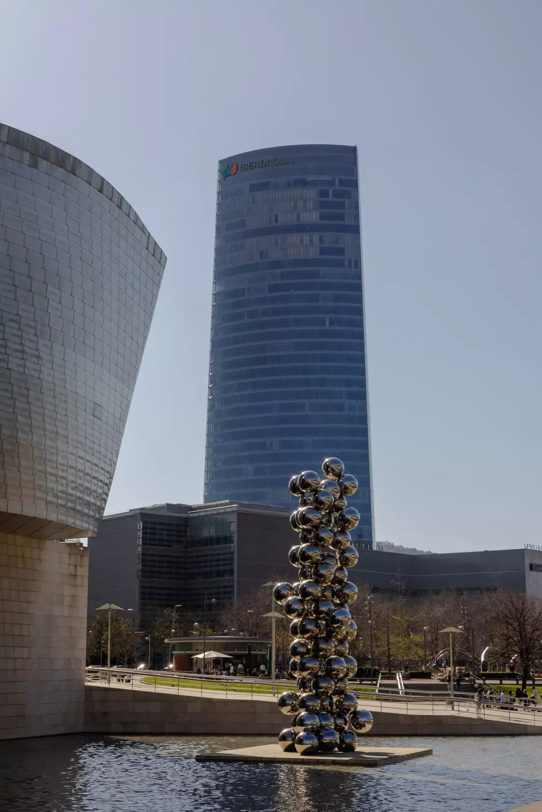 A metallic sculpture in a plaza outside a museum building.