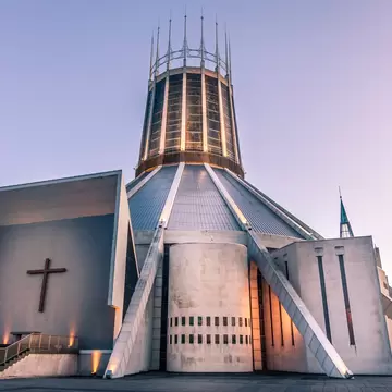 Front view of the Roman Catholic Liverpool Metropolitan Cathedral with stained glass panels at the base of the steps in the foreground, Liverpool, Merseyside, England.