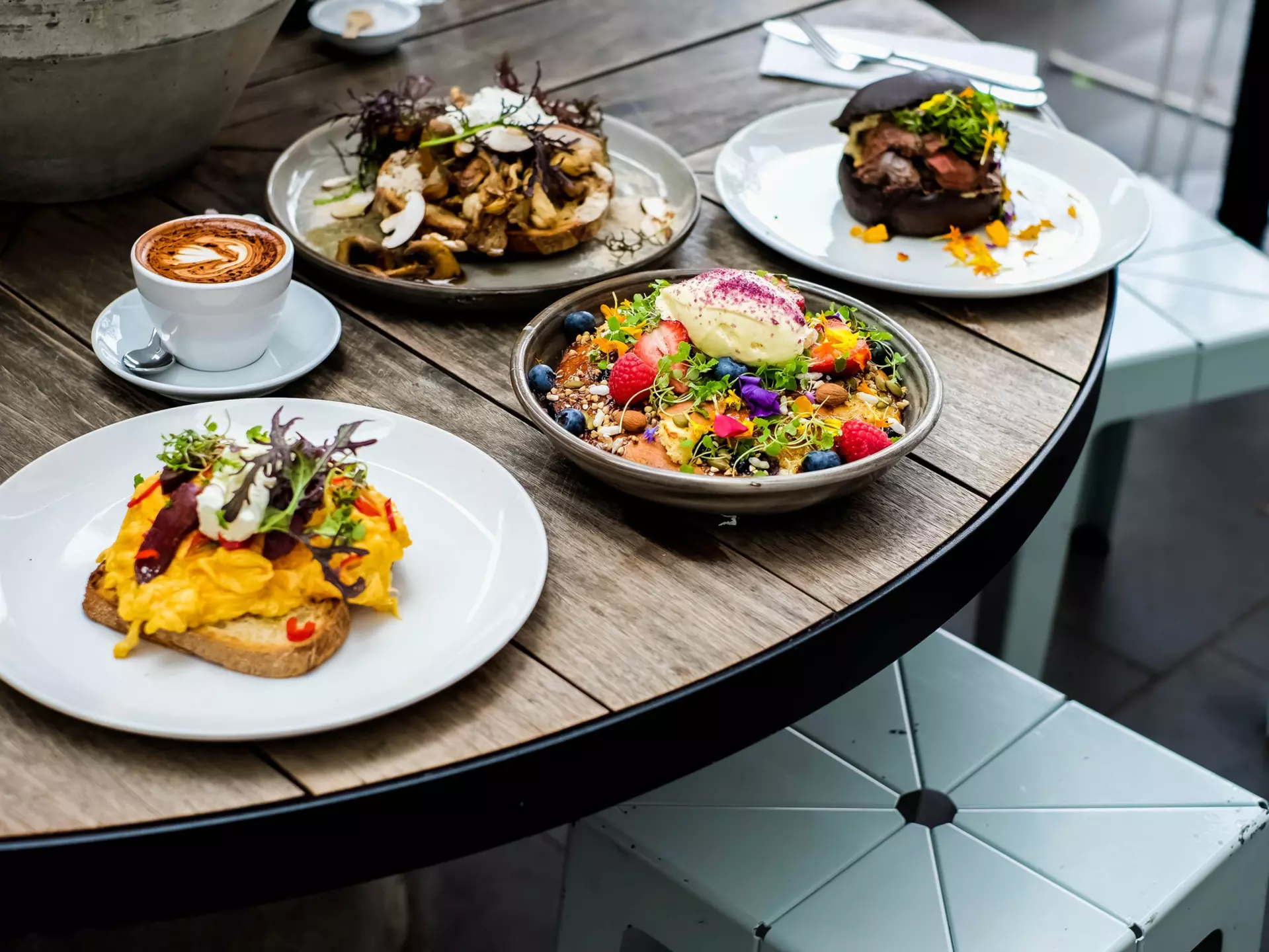 Closeup of a Kangaroo burger topped with sauce, greens and onions and a side of french fries