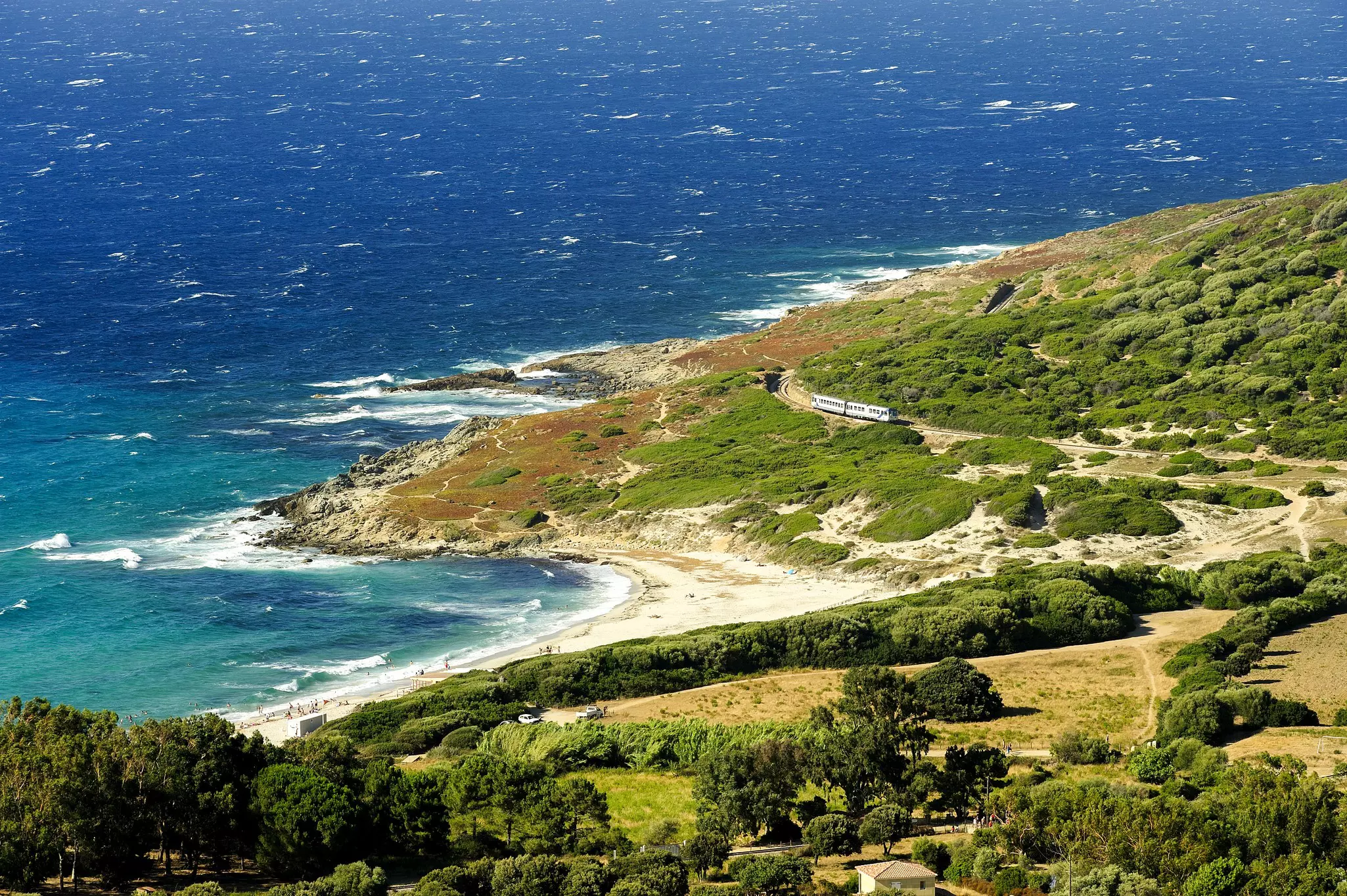 The train hugs the coastline as it travels past along Bodri beach near Corse © REDA&CO/Getty Images