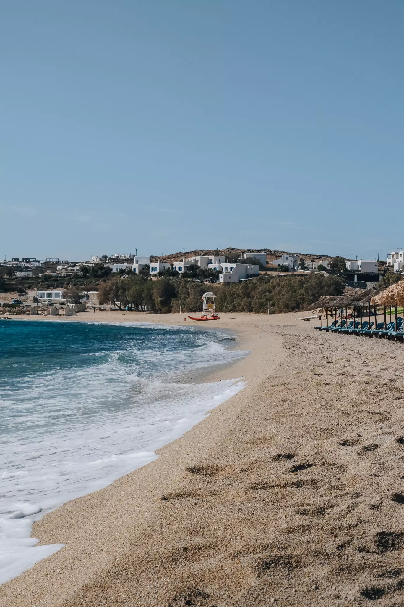  Waves washing up on Kalafati beach, a popular beach in Mykonos famous for water sports, on a sunny summer day.