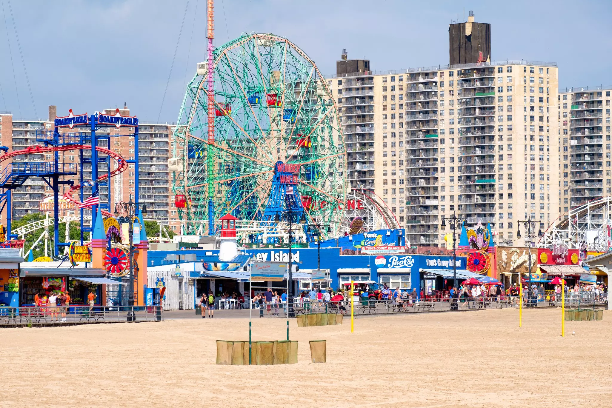 An amusement park on a boardwalk by the beach.