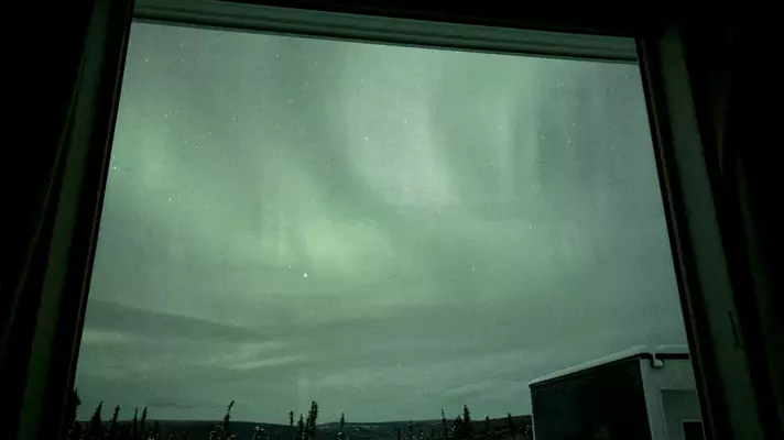 Hazy wisps in a greenish sky through a window in Fairbanks, Alaska.
