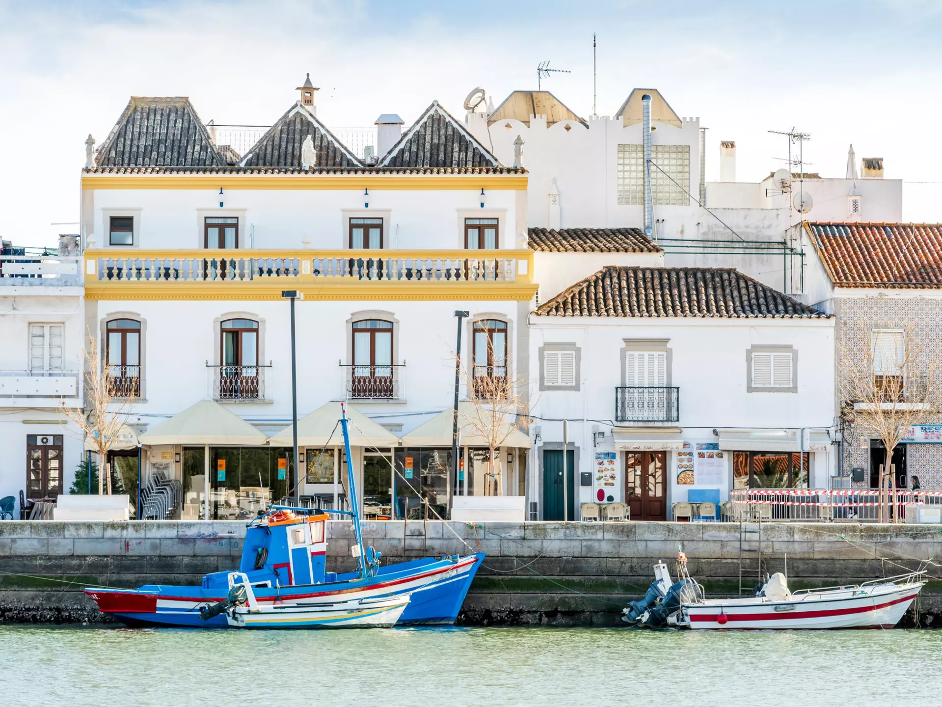 The charming architecture of Tavira with boats on the Gilão River. Sopotnicki/Shutterstock