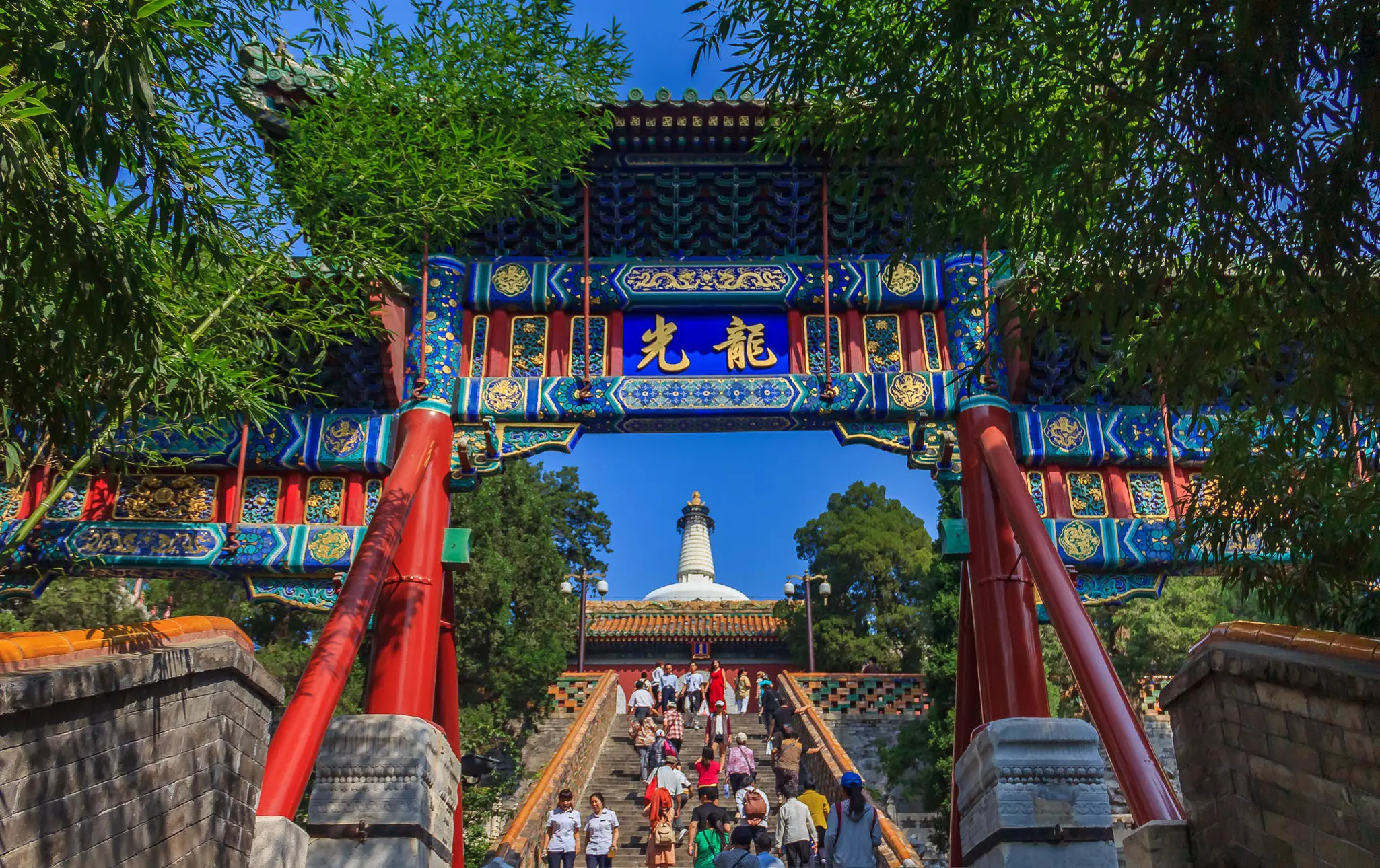People on the steps leading to the Bai Ta stupa at the Buddhist Yong An Temple of Everlasting Peace in Beihai Lake Park, Beijing, China.