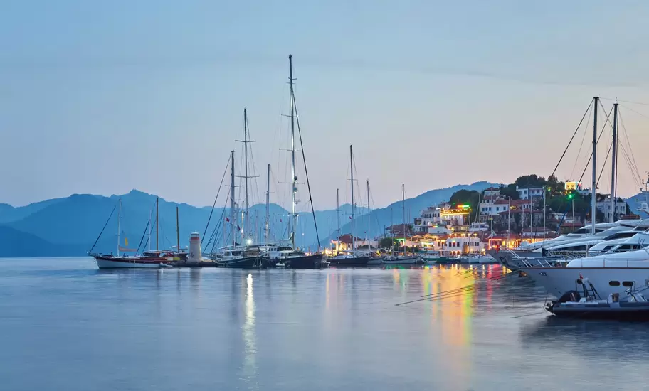 A marina with sailboats at dusk.