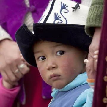 Young boy wearing traditional kalpak felt hat.