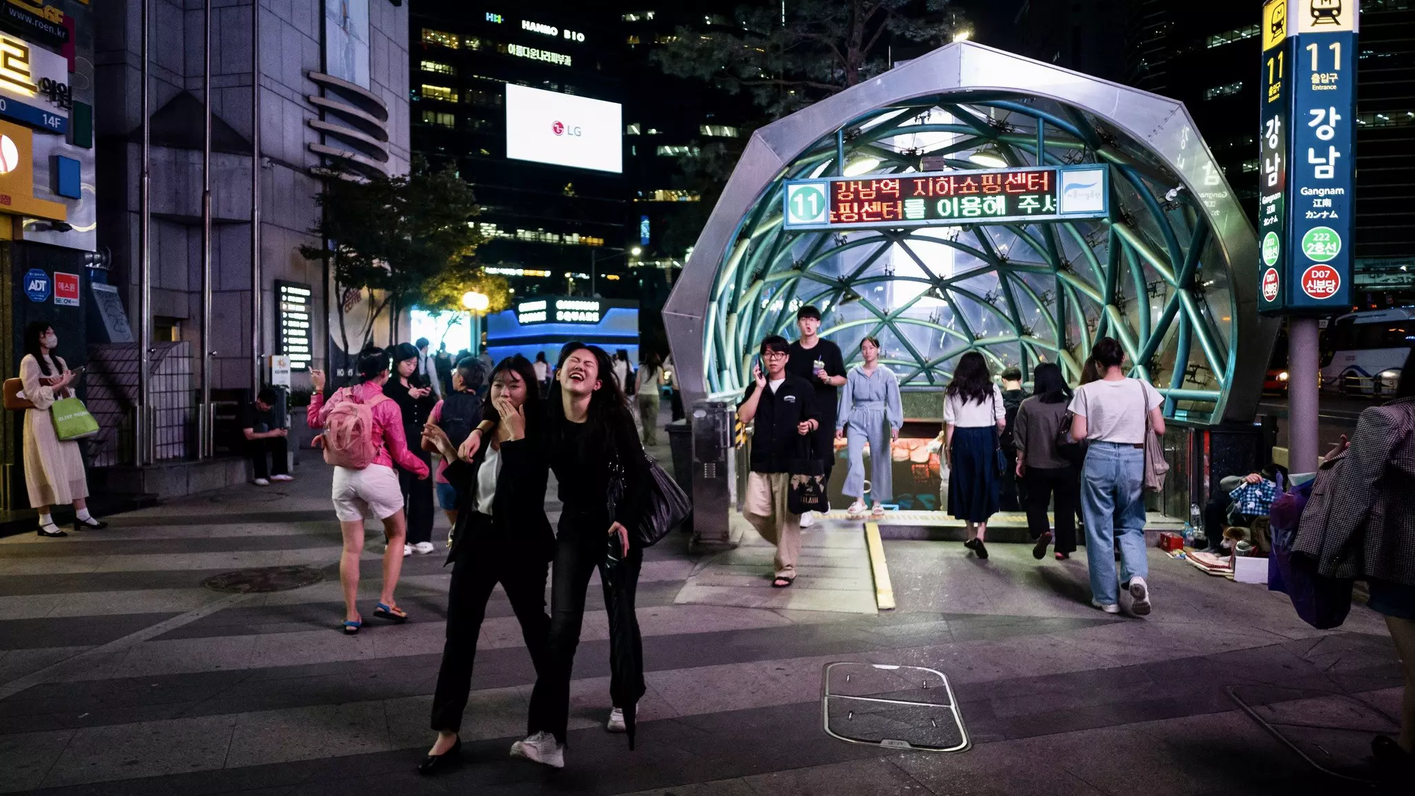 Pedestrians walk past the Gangnam metro underground train station in Seoul.