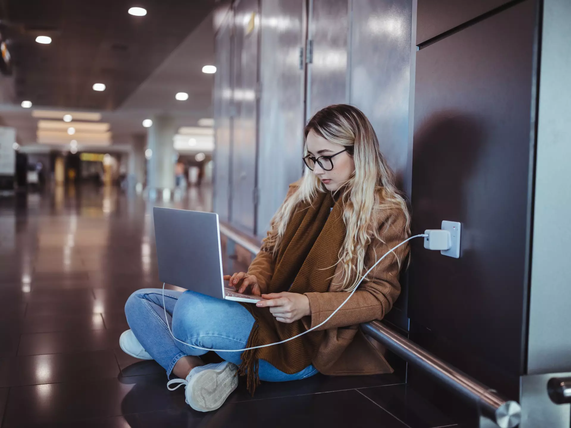 Woman using laptop while waiting for flight departure at airport