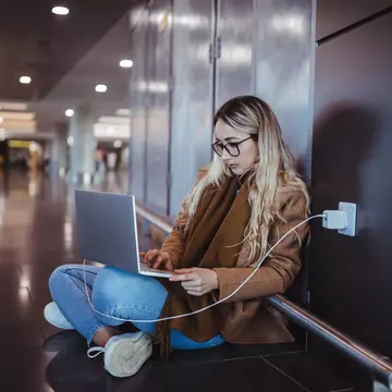 Woman using laptop while waiting for flight departure at airport