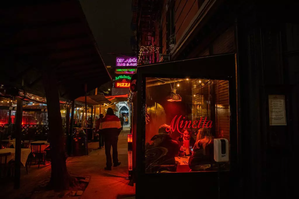 People eat in the outdoor seating of the Minetta Tavern restaurant in the Greenwich Village neighborhood of New York, U.S.
