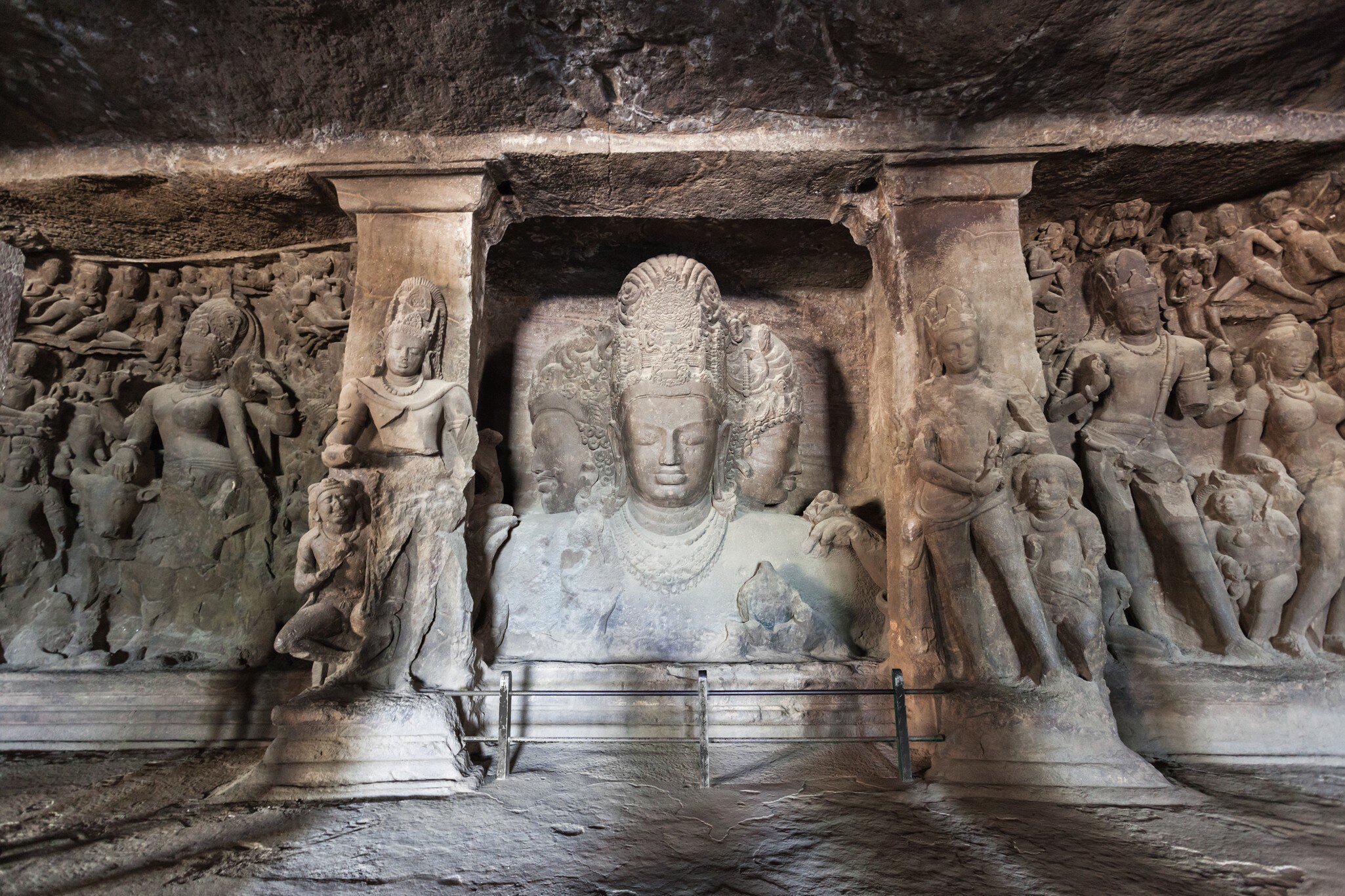 Relief carvings of figures in stone in a cave on Elephanta Island in Mumbai, India.