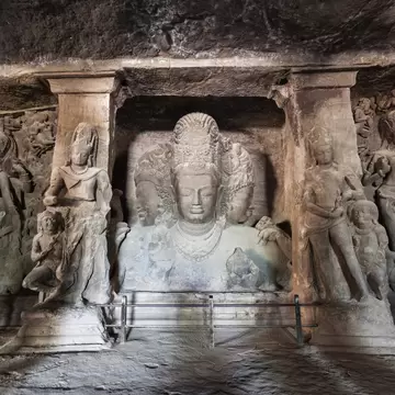 Relief carvings of figures in stone in a cave on Elephanta Island in Mumbai, India.